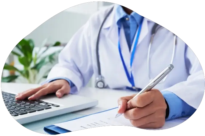 médico omando notas en papel con notebook a su lado